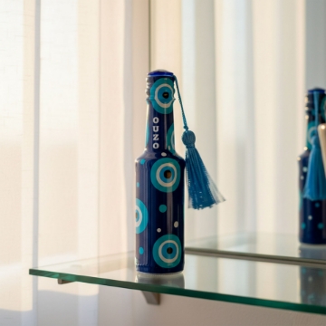 Ouzo Paired with Traditional Greek Meze A flat lay photo showing a glass of ouzo next to a small plate with Greek meze, including olives, feta cheese, and cherry tomatoes.