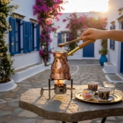 Brewing traditional Greek coffee in an engraved copper briki on a patio in Greece, served with loukoumi